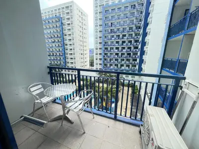a balcony with a table and chairs and buildings at Sea Residences MoaPasay City By Jerson in Manila