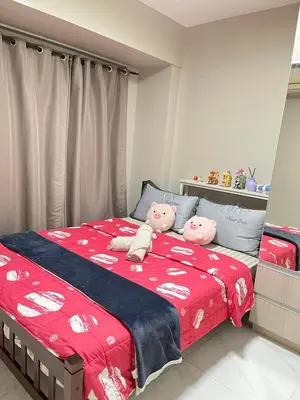 two hello kitty stuffed animals sitting on a bed at Monarch parksuites 1bedroom with free pool access in Manila