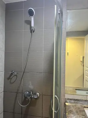 a shower with a shower head in a bathroom at Monarch parksuites 1bedroom with free pool access in Manila