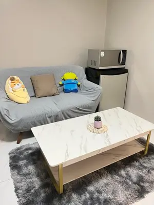 a living room with a couch and a table at Monarch parksuites 1bedroom with free pool access in Manila