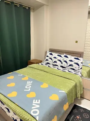 a bedroom with two beds and a green curtain at Monarch parksuites 1bedroom with free pool access in Manila