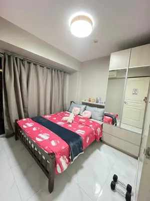 a bedroom with a bed with two stuffed animals on it at Monarch parksuites 1bedroom with free pool access in Manila