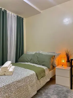 a bedroom with a bed with green curtains at The Cozy Cove - 3BR with Netflix, Prime and KTV in Manila