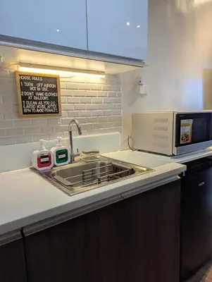 a kitchen with a sink and a microwave at d'DEN at SMDC AIR Makati 1BR Bay view in Manila