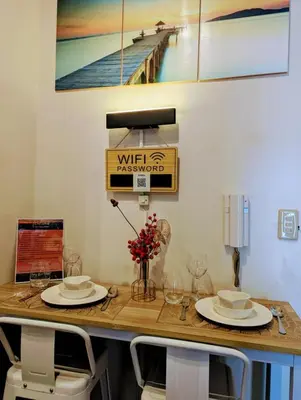 a table with chairs and a sign that reads wirksworth at d'DEN at SMDC AIR Makati 1BR Bay view in Manila