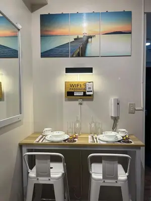 a dining table with two chairs and a pier at d'DEN at SMDC AIR Makati 1BR Bay view in Manila