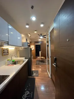 a kitchen with a sink and a refrigerator at d'DEN at SMDC AIR Makati 1BR Bay view in Manila