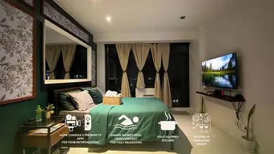 a bedroom with a green bed and a television at Max 1 Small Pet Allowed! Choose Pet Rate Plan if you have a pet with you! Gramercy Residences at 42nd Floor with Pool and Gym Access in Manila