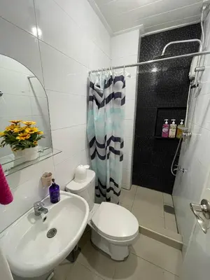 a bathroom with a toilet and a sink and a shower at 19f w NFLIX & BALCONY NEAR ROB, PGH, ACC USM&SLMC in Manila