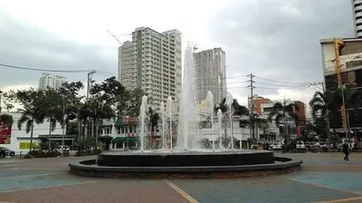 a fountain in the middle of a city with tall buildings at 19f w NFLIX & BALCONY NEAR ROB, PGH, ACC USM&SLMC in Manila