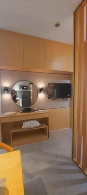 a room with a tv on a table with a mirror at MODERN ZEN Den in Manila