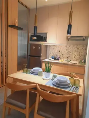 a kitchen with a wooden table with chairs and plates at MODERN ZEN Den in Manila