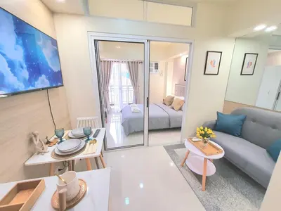 a living room with a couch and a table at Lovely, Cozy One Bedroom with Wi-fi Pool in Pasig in Manila