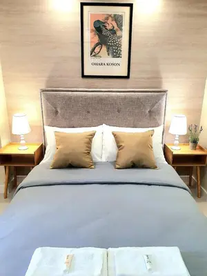 a bedroom with a bed with two lamps on two tables at Lovely, Cozy One Bedroom with Wi-fi Pool in Pasig in Manila