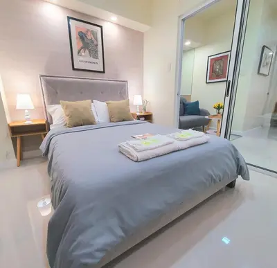 a bedroom with a large bed with two towels on it at Lovely, Cozy One Bedroom with Wi-fi Pool in Pasig in Manila