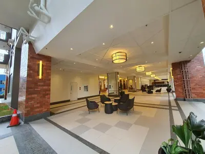a lobby with couches and chairs in a building at Lovely, Cozy One Bedroom with Wi-fi Pool in Pasig in Manila
