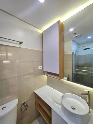 a bathroom with a sink and a toilet and a mirror at Franchelle Bliss - Shore 2 Residences Tower 1 in Manila