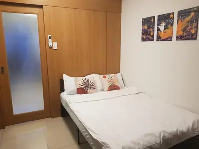 a bedroom with a bed with a door and pillows at Newly Renovated Shell Residences Mall of Asia Condo in Manila