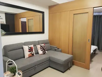 a living room with a couch and a mirror at Newly Renovated Shell Residences Mall of Asia Condo in Manila