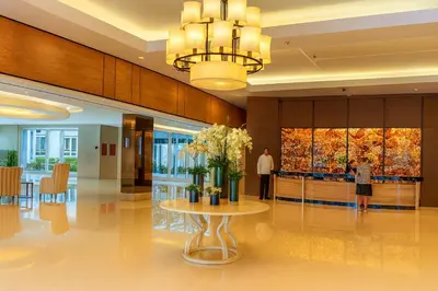 a lobby with a table with flowers on it at Newly Renovated Shell Residences Mall of Asia Condo in Manila