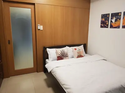 a bedroom with a bed with white sheets and pillows at Newly Renovated Shell Residences Mall of Asia Condo in Manila