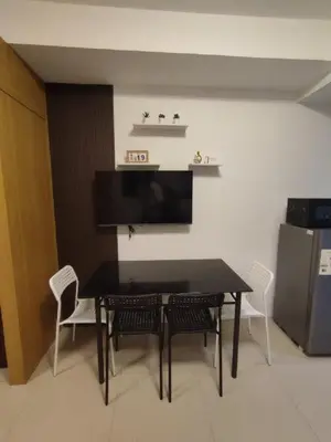 a dining room with a black table and chairs at Newly Renovated Shell Residences Mall of Asia Condo in Manila