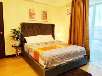 a bedroom with a bed in a room with a window at Velvet Accommodation PH in Manila