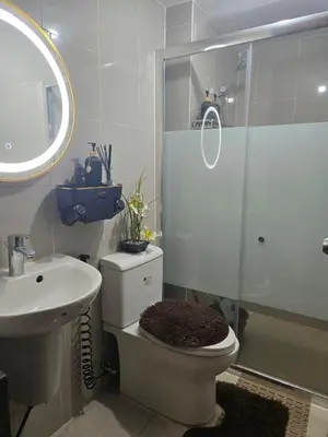 a bathroom with a shower and a toilet and a sink at Velvet Accommodation PH in Manila