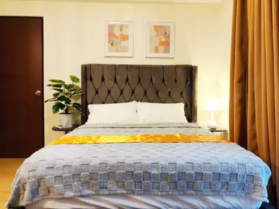 a bedroom with a bed with a blue and yellow comforter at Velvet Accommodation PH in Manila