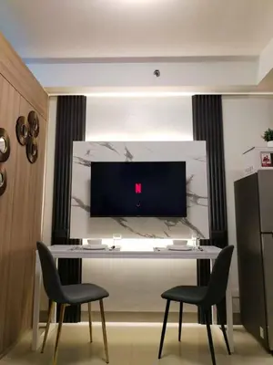 a room with a table with two chairs and a tv at Qween E Choice 2 Qween bed Condo in Manila
