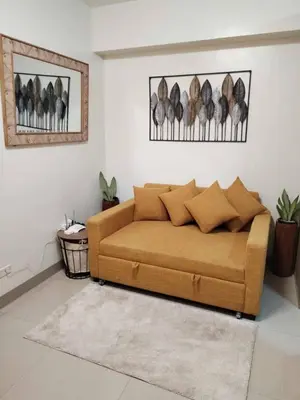 a living room with a brown couch in a room at Qween E Choice 2 Qween bed Condo in Manila