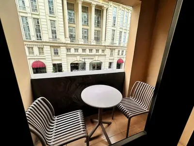 a balcony with a table and two chairs and a window at Hestia Homes near Airport in Manila