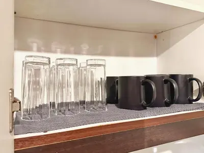 a row of wine glasses sitting on a shelf at Hestia Homes near Airport in Manila