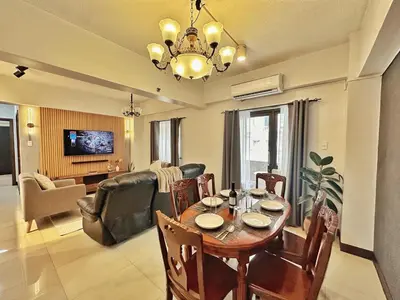a living room with a dining table and a living room with a couch at Hestia Homes near Airport in Manila