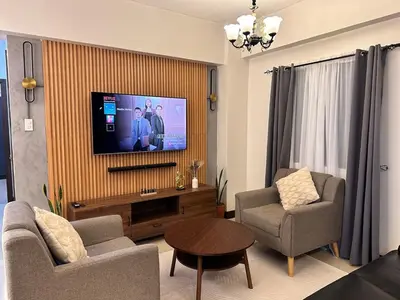 a living room with a flat screen tv on a wall at Hestia Homes near Airport in Manila