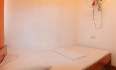 a small room with a bed and a phone on the wall at Stay Malate Hostel by RedDoorz in Manila