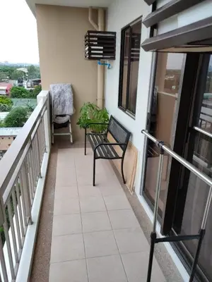 a balcony with a bench and a chair on a building at Condo unit in Sucat, Paranaque Calathea Place in Manila
