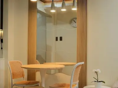 a table and chairs in a room with a clock on the wall at Cozy Crib2 in Manila