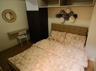 a bedroom with a bed and a mirror on the wall at Cozy Crib2 in Manila