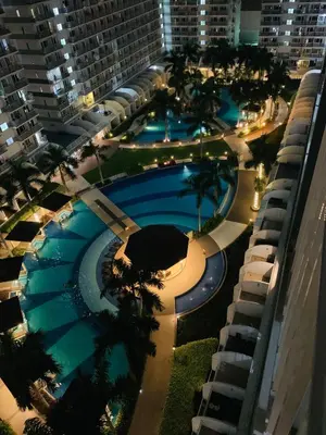 an overhead view of a large swimming pool at night at Kathys Crib 2Bedroom MOA View at Shell Residence in Manila