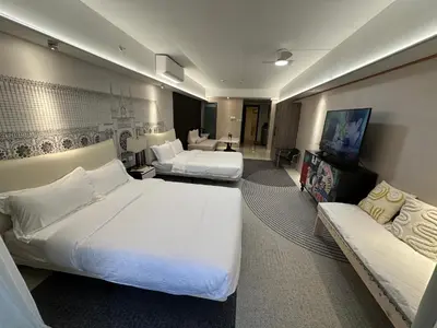 a hotel room with two beds and a couch at Spacious Apartment Hotel near City of Dreams, Airport, MOA, Okada, Ayala Malls, and Solaire Casino with free 5 pool access in Manila