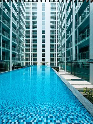 a large swimming pool in a building with tall buildings at Spacious Apartment Hotel near City of Dreams, Airport, MOA, Okada, Ayala Malls, and Solaire Casino with free 5 pool access in Manila