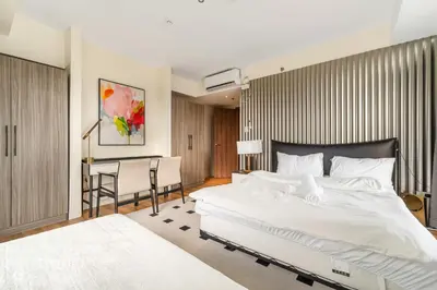 a bedroom with a large white bed and a desk at Spacious Unit & High-Floor Hotel near City of Dreams, Airport, Okada, and Solaire Casino in Manila