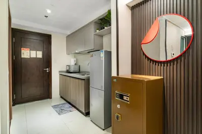 a kitchen with a refrigerator and a mirror on the wall at Spacious Unit & High-Floor Hotel near City of Dreams, Airport, Okada, and Solaire Casino in Manila