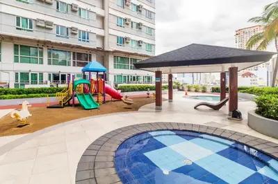 a playground with a slide and a swing set at Kintai Suites at the Beacon in Manila