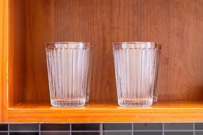 two empty glasses sitting on a wooden shelf at Kintai Suites at the Beacon in Manila