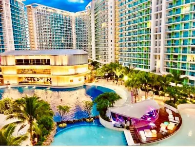 an aerial view of a resort with palm trees and buildings at 2br in Azure with Manila Bay View & Laguna de Bay View in Manila