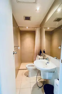 a bathroom with a white toilet and a sink at 2br in Azure with Manila Bay View & Laguna de Bay View in Manila