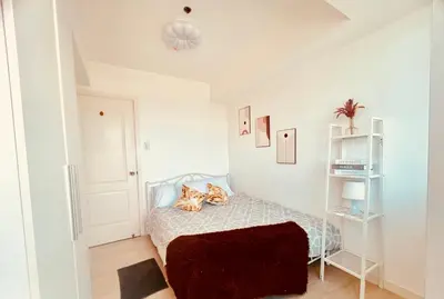 a bedroom with a bed with two cats laying on it at 2br in Azure with Manila Bay View & Laguna de Bay View in Manila