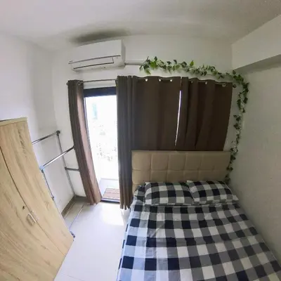 a small bedroom with a bed with a checkered blanket at MAKATI - Lush Residences in Manila